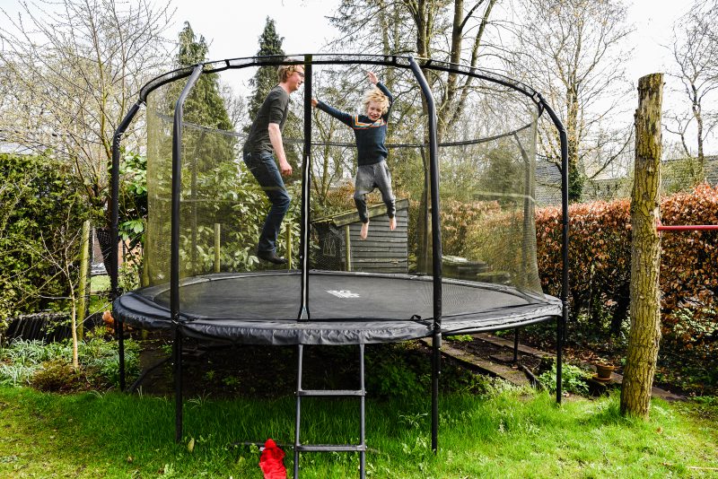 Day in the life, familie reportage, trampoline, jongen met vader springen, fotograaf Assen, natuurlijkliacht fotograaf, fotograaf in Drenthe.