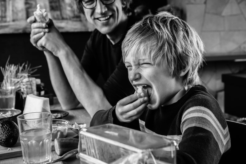 day in the life, familie reportage, bij mensen thuis fotograferen, kind eet citroen, fotograaf Assen, natuurlijkliacht fotograaf, fotograaf in Drenthe, gezamenlijk eten aan tafel